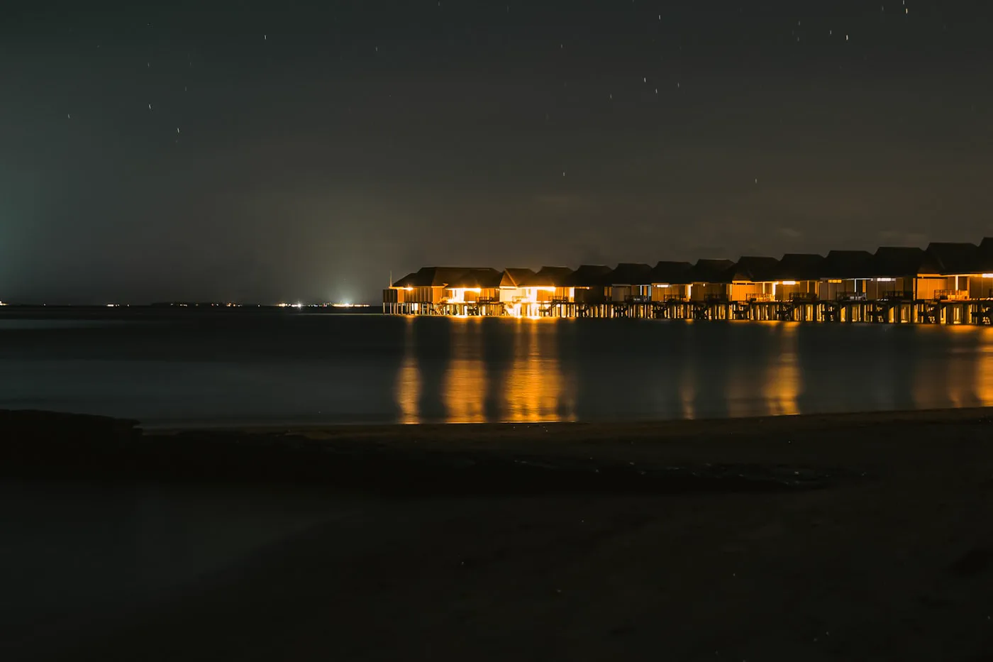Villa lights on the water at night
