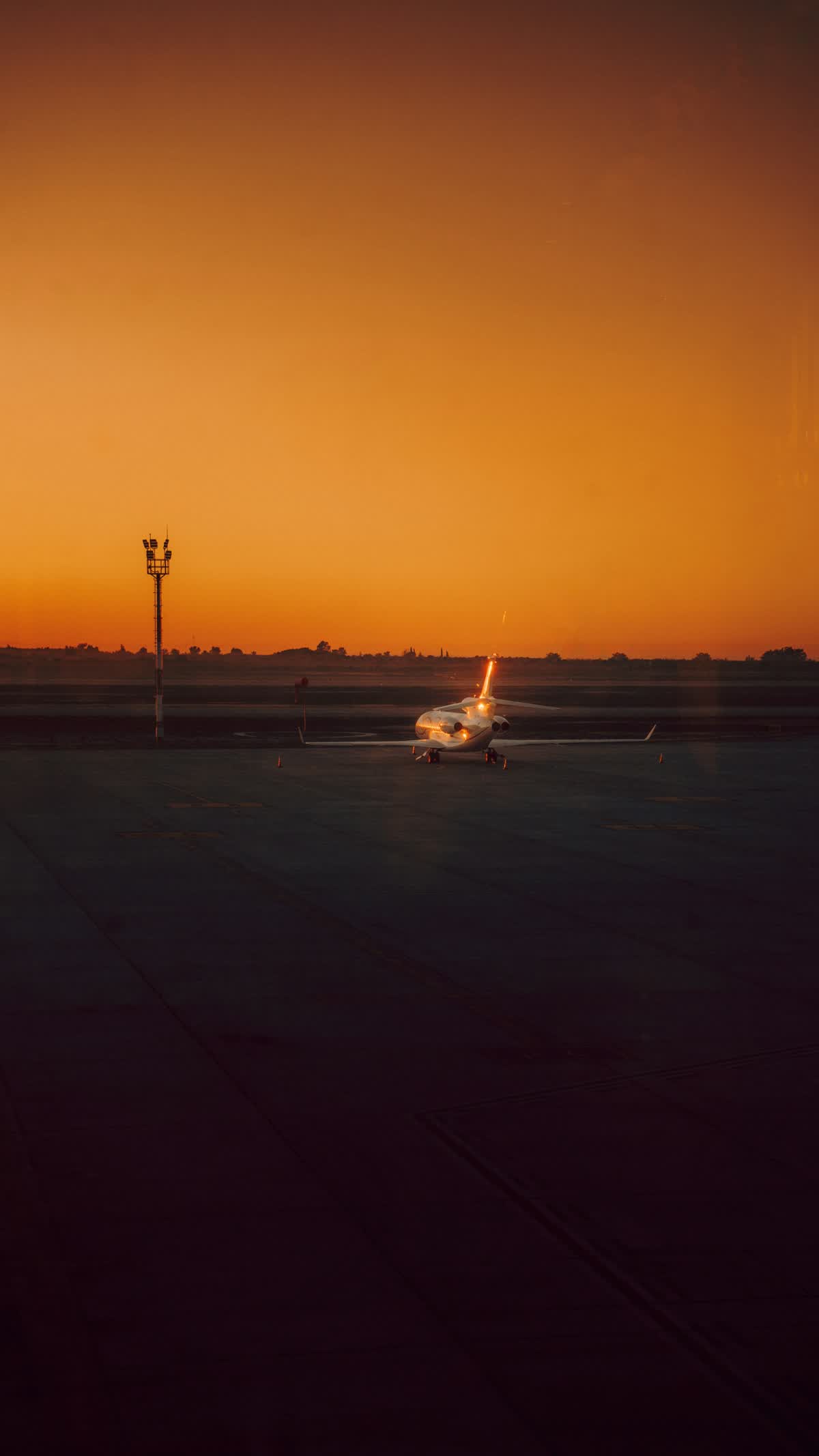 A private jet on the tarmac at sunset