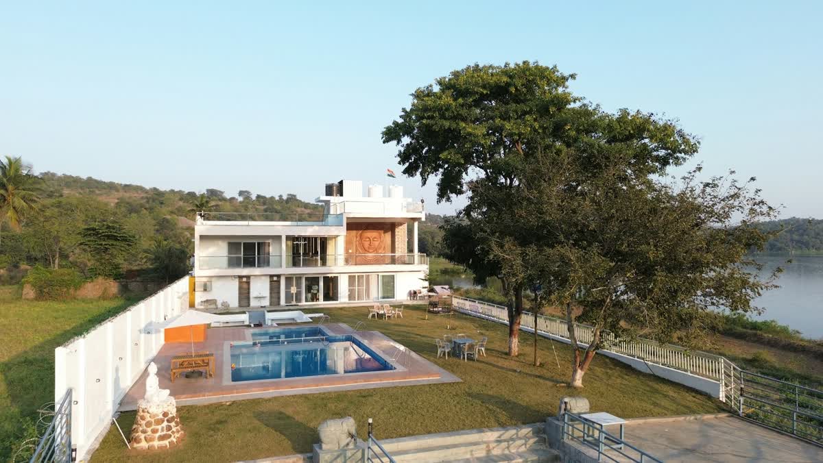 A mountain house with a pool beside a lake